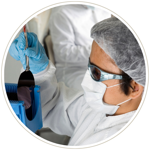 Woman inspecting a semiconductor wafer at electronics - semiconductor company in the USA